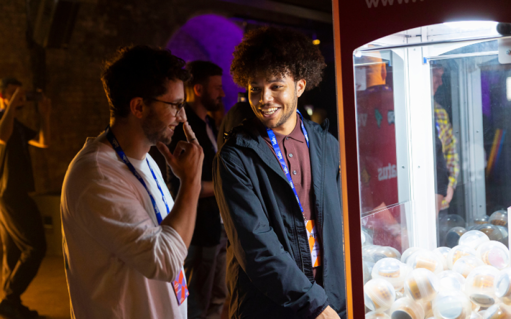 two members playing with the claw machine 