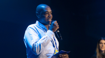 Man on stage holding microphone